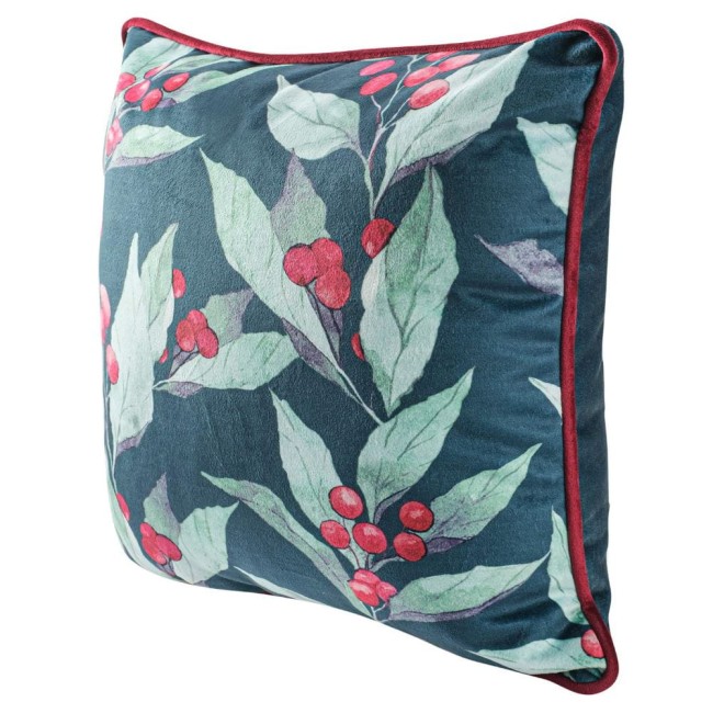 Zielona poszewka dekoracyjna 43x43 cm z nadrukiem liści i czerwonych jagód. Ujęcie z boku, produktu w pozycji leżącej. Miękka, teksturowana powierzchnia z kontrastującą bordową lamówką. Tło jednolite, co podkreśla wzór.