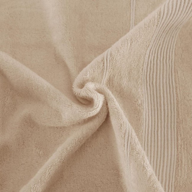 Ręcznik bambusowy 70x140 w kolorze cappuccino, z teksturą miękkiego materiału. Produkt leży na płaskiej powierzchni, widoczne detale w postaci poziomych pasków. Tło jest jednorodne i neutralne, podkreślające kolor ręcznika.