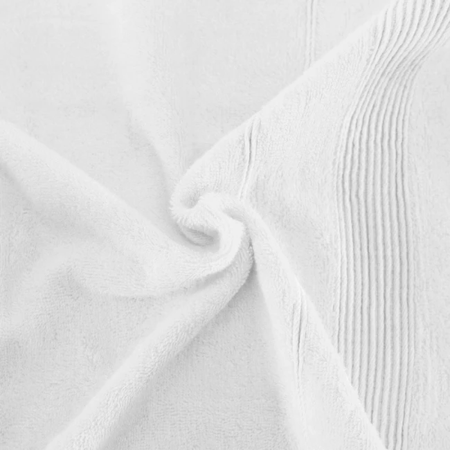 Ręcznik bambusowy 70x140 w kolorze białym, leżący na jasnym tle. Produkt ma miękką, teksturowaną powierzchnię oraz subtelną strukturalną dekorację po jednej stronie. Widoczny kształt podkreśla jego rozmiar i gęstość włókien.