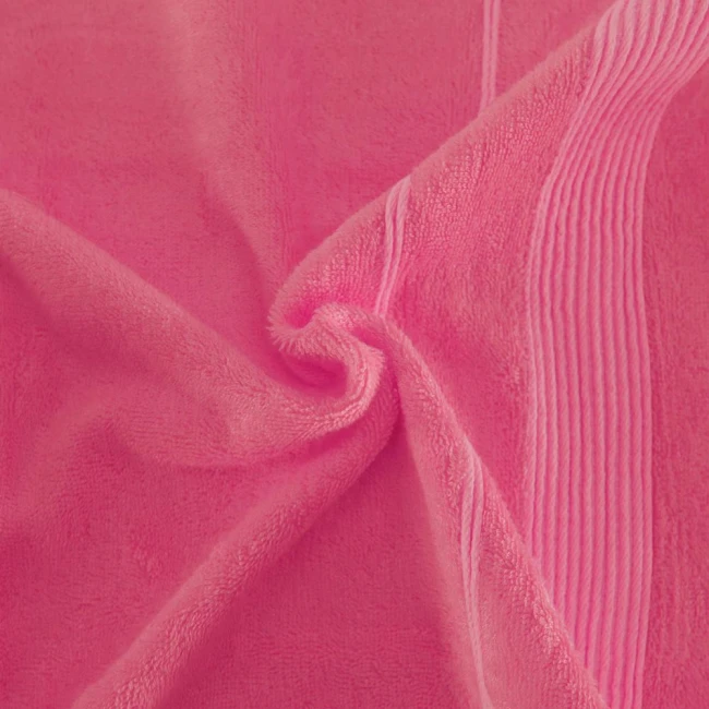 Ręcznik bambusowy 70x140 w kolorze fuksji, o miękkiej, teksturowanej strukturze. Widok w zbliżeniu, ukazujący zgięcie materiału oraz delikatne wdrożenie wzoru, z jasnymi liniami. Tło jednolite, podkreślające intensywność koloru.