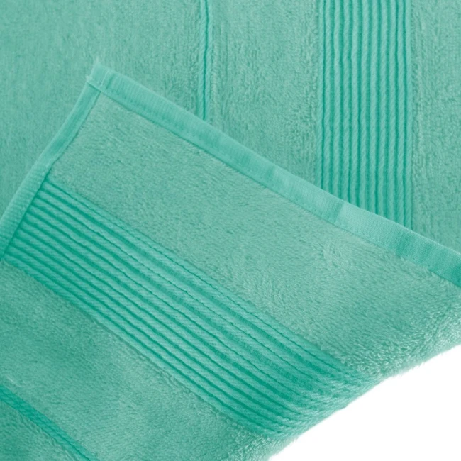 Ręcznik bambusowy 70x140 cm w kolorze błękitnym, z gładką fakturą i delikatnym, strukturalnym wykończeniem. Złożony w rogu, prezentuje się na jednolitym tle, umożliwiając widoczność szczegółów materiału oraz wykończenia.