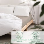 Prześcieradło satynowe bez gumki 160x220 w kolorze ciemnego beżu, rozłożone na łóżku z drewnianą ramą. Tło w jasnych odcieniach, poduszki obok. Materiał gładki, matowy, z lekkim połyskiem, dobrze dopasowuje się do kształtu materaca.