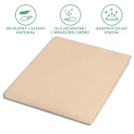 Prześcieradło satynowe, rozmiar 200x220 cm, w kolorze jasnego beżu, z miękką i gładką fakturą, leżące płasko. Widoczne symbole dotyczące delikatności materiału i jego właściwości, na jednolitym tle. Produkt przeznaczony dla skóry wrażliwej.
