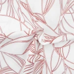 Pościel bawełniana 160x200 Cottonlove Exclusive Lenny w kolorze białym z delikatnym, czerwonym wzorem roślinnym. Złożona, z wyraźnie widoczną teksturą materiału. Ujęcie z bliska, ukazujące detale splotu tkaniny.