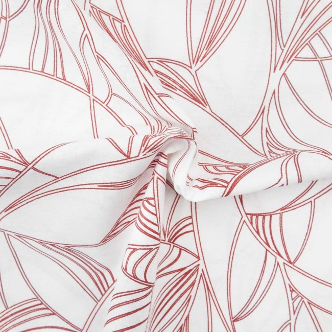 Pościel bawełniana 160x200 Cottonlove Exclusive Lenny w kolorze białym z delikatnym, czerwonym wzorem roślinnym. Złożona, z wyraźnie widoczną teksturą materiału. Ujęcie z bliska, ukazujące detale splotu tkaniny.