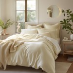 Pościel satyna bawełniana 220x200 w kolorze kremowym, rozłożona na łóżku. Widoczne dodatki to poduszki w różnych kształtach oraz pleciony koc. Całość w jasnym wnętrzu z oknem i roślinnością, na białym tle, w naturalnym świetle.