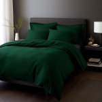 Pościel satyna bawełniana 160x200 w ciemnozielonym kolorze, z poziomymi prążkami, złożona na łóżku. W tle widoczna szara ściana i nocna lampka. Zestaw obejmuje poszewki na poduszki oraz narzutę na kołdrę, całość ładnie zaaranżowana.
