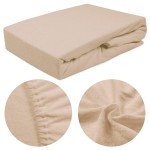 Prześcieradło frotte z gumką 120x200 w kolorze beżowym, leżące na płaskiej powierzchni, z widoczną miękką fakturą materiału. Detal skupiony na gumce, która zapewnia dobre dopasowanie. Tło jednolite, co podkreśla produkt.