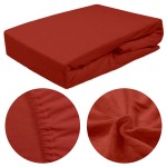 Prześcieradło frotte z gumką 180x200 w kolorze bordo, leżące na jednolitym tle. Zbliżenie na fakturę materiału oraz detale gumki, podkreślające elastyczność. Prześcieradło z charakterystyczną, miękką powierzchnią.