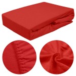 Prześcieradło frotte z gumką 180x200 w intensywnym kolorze czerwonym, leżące na płasko. Zbliżenie na fakturę materiału oraz gumkę, która zapewnia stabilne dopasowanie. Gładka powierzchnia z miękką, przyjemną w dotyku strukturą.
