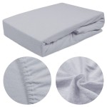 Prześcieradło frotte z gumką w kolorze popielatym o wymiarach 200x220 cm, leżące na jednolitym tle. Zbliżenie na miękką teksturę dzianiny oraz gumkę, zapewniającą dobre dopasowanie do materaca. Widoczne szczegóły wykończenia krawędzi.