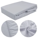 Prześcieradło frotte z gumką 90x200 w kolorze popielatym, leżące na płasko. W zbliżeniu widoczna struktura materiału oraz elastyczna gumka na brzegach, zapewniająca lepsze dopasowanie. Tło proste, szare, podkreślające produkt.