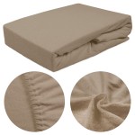 Prześcieradło frotte z gumką 160x200 w kolorze kakao, leżące płasko. Materiał o teksturze frotte, widoczne detale gumki oraz układ fałd na powierzchni. Zbliżenie na fakturę materiału i brzegi. Tło jednolite, podkreślające kolor prześcieradła.