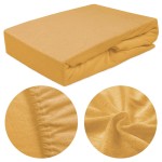 Prześcieradło frotte z gumką 200x220 w kolorze musztardowym, leżące na białym tle. Zbliżenie na teksturę dzianiny oraz gumkę, która zapewnia stabilne dopasowanie. Gładka powierzchnia i intensywny kolor dodają atrakcyjności.