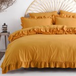 Pościel bawełniana z falbanką w kolorze żółtym, w rozmiarze 160x200, ukazana leżąco na łóżku. Materiał ma gładką fakturę z dekoracyjnym falbankowym wykończeniem. W tle widoczny rattanowy zagłówek oraz lampion na drewnianym stoliku.