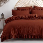Pościel bawełniana 160x200 w kolorze ceglanym, z falbanką. Ułożona poziomo na łóżku, z widocznymi dwoma poduszkami. Materiał gładki, z delikatnym połyskiem. Tło proste, białe. Falbanka widoczna przy dolnej krawędzi narzuty, nadająca elegancki wygląd.