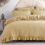 Pościel bawełniana w kremowym kolorze z falbanką, rozłożona na łóżku, z poszewkami na poduszki w tym samym odcieniu. Widoczne detale to miękka faktura materiału i dekoracyjna falbanka na brzegach. Ujęcie frontalne, w przytulnym wnętrzu.