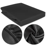 Prześcieradło satynowe z gumką 160x200 w kolorze czarnym, leżące na płasko. Widoczne detale gumki oraz faktura materiału. W zbliżeniu pokazano elementy wykończenia, ukazujące gładką powierzchnię. Tło proste, jednolite.