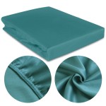 Prześcieradło satynowe z gumką w rozmiarze 160x200, w kolorze ciemnego turkusu, leżące na jednolitym tle. W zbliżeniu widoczna faktura materiału oraz gumka zapewniająca stabilność. Detal na brzegach ukazuje staranne wykończenie i zszycie.