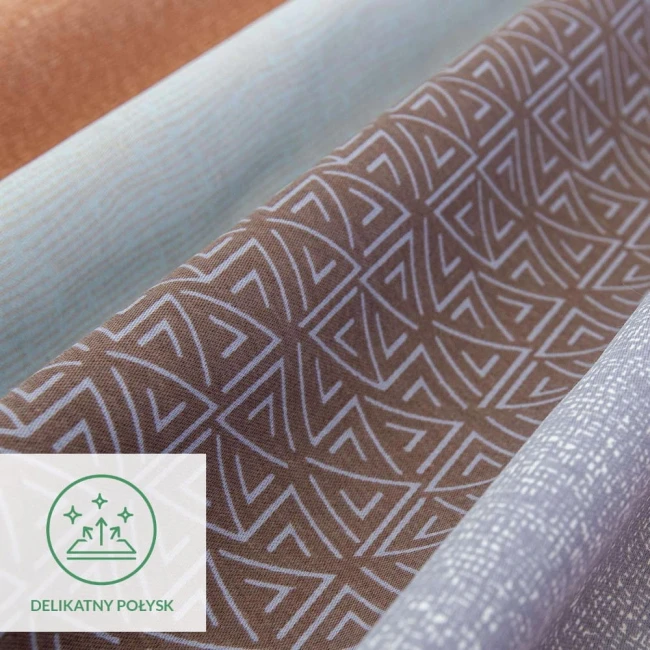 Satynowa pościel w kolorze pomarańczowo-brązowym z geometrycznym wzorem. Materiał delikatny, matowy z subtelnym połyskiem. Ułożenie tkanin w złożony sposób, widoczne różne odcienie. Element identyfikacyjny Delikatny połysk w lewym dolnym rogu.