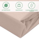 Ochronne prześcieradło z gumką w kolorze beżowym, wykonane z oddychającego materiału. Widoczne fałdy tkaniny, która jest miękka i przyjemna w dotyku. Ujęcie z boku, ukazujące detale materiału oraz gumkę, która zapewnia stabilne mocowanie.