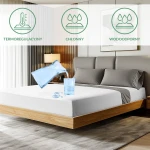 Ochronne prześcieradło z gumką w kolorze białym, o wymiarach 90x200 cm, leży na łóżku z jasnym drewnianym stelażem. Produkt przedstawiony w kontekście wnętrza sypialni. Na prześcieradle widać rozlaną wodę z szklanki, co ilustruje jego wodoodporność.