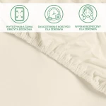 Ochronne prześcieradło z gumką 140x200 w kolorze kremowym, leżące na gładkiej powierzchni. Widoczna elastyczna guma wokół prześcieradła, która zapewnia stabilne dopasowanie. Detale dotyczące zdrowotnych właściwości są czytelne w górnej części zdjęcia.