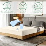 Ochronne prześcieradło z gumką w kolorze kremowym o wymiarach 60x120 cm, położone na łóżku w aranżacji sypialni. Na prześcieradle widoczne plamy wody, jako ilustracja jego wodoodporności.