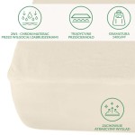 Ochronne prześcieradło z gumką w kolorze kremowym, rozmiar 60x120 cm. Produkt leży płasko na jasnym tle. Widoczne grafiki informacyjne o funkcji ochronnej i gramaturze materiału. Gładka tekstura tkaniny, elastyczne brzegi gumki.