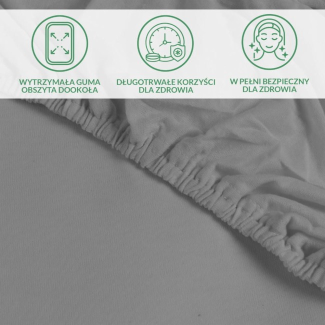 Ochronne prześcieradło z gumką w kolorze szarym, wykonane z materiału o gładkiej fakturze. Ujęcie z góry w zbliżeniu na elastyczną gumkę obszytą wokół rogów. Widoczne symbole dotyczące trwałości i zdrowotnych korzyści.