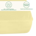 Ochronne prześcieradło z gumką 60x120 w kolorze kremowym, naciągnięte na materac. Posiada grafikę przedstawiającą funkcję ochrony przed wilgocią i zabrudzeniami. Ułożone poziomo z widocznym kształtem krawędzi. Tło jednolite i neutralne.