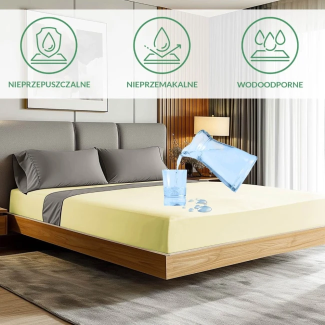 Ochronne prześcieradło z gumką w kolorze kremowym, o wymiarach 70x140 cm, rozłożone na łóżku. Widoczne napisy informujące o właściwościach: nieprzepuszczalne, nieprzemakalne, wodoodporne. Ujęcie w aranżacji sypialni, z szarym zagłówkiem i lampką w tle.