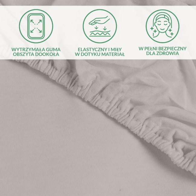 Ochronne prześcieradło z gumką w kolorze popiel. Widoczne elastyczne obszycie z wytrzymałej gumy oraz gładka, przyjemna w dotyku tekstura materiału. Ujęcie z boku, pokazujące detale wykończenia. Idealne do materaca 90x200 cm.