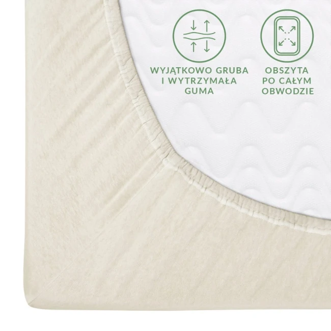 Prześcieradło jersey z gumką w kolorze ecru, rozmiar 80x180, prezentowane z boku. Widoczna gruba, elastyczna guma obwodowa oraz tekstura materiału. Na powierzchni znajdują się napisy informacyjne o właściwościach produktu.
