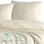 Pościel satyna bawełniana 200x220 w kolorze ecru, z geometrycznym wzorem. Złożona na łóżku, w górnym rogu widoczne dwa poszewki na poduszki. Materiał ma delikatny połysk, zapewniający elegancki wykończenie. Niezwykle miękka i przyjemna w dotyku.