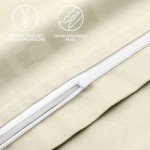 Pościel satyna bawełniana 200x220 w odcieniu ecru, z wzorem geometrycznym. Widoczny detal zamka błyskawicznego, zasłonięty plisą. Ujęcie w zbliżeniu na zdobienia i tkaninę, która ma teksturowaną powierzchnię.