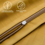 Zbliżenie na zamek błyskawiczny pościeli satynowej w geometrycznym wzorze w kolorze żółtym. Widoczny zamek jest osłonięty plisą, co zapewnia estetyczny wygląd. Tło jest jednolite, co podkreśla detale oraz teksturę materiału.