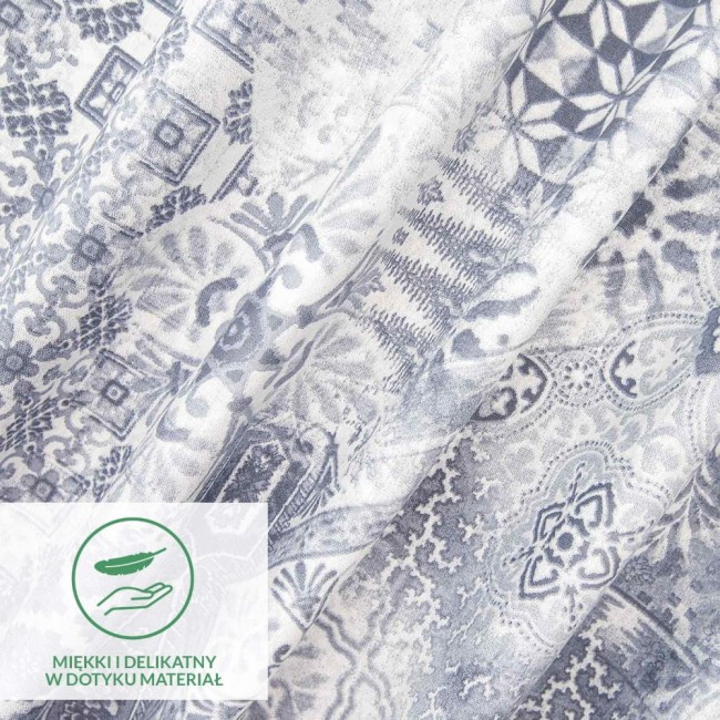 Pościel bawełniana 200x220 Cottonlove Exclusive Pava w odcieniach bieli i szarości, z ornamentami w różnych kształtach. Materiał jest miękki w dotyku. Zdjęcie zbliżeniowe ukazuje detale wzoru oraz fakturę tkaniny. Tło jest jasne i jednolite.