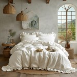 Komplet poszewek bawełnianych z falbanką 2x40x40 cm w kolorze szlachetnej bieli, leżący na łóżku. Widoczne delikatne falbanki oraz poduszki w tle. Elementy dekoracyjne obejmują stół z tkaniną, filiżanki i gałązki. Jasne, naturalne tło z oknem.