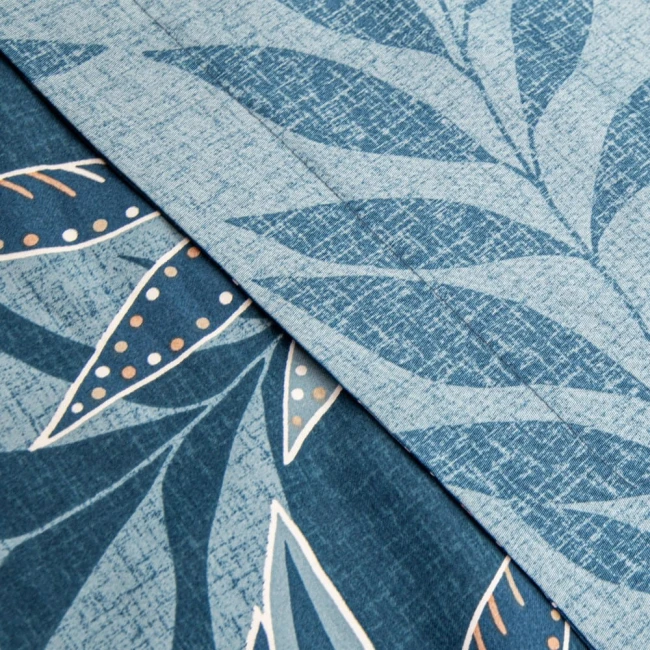 Pościel satyna bawełniana 220x200 Luxury Premium Irene w odcieniach niebieskiego ze wzorem delikatnych liści. Widoczny detal faktury materiału oraz kolorowe akcenty, stworzona do aranżacji sypialni. Złożona, ukazująca dwa różne ornamenty.