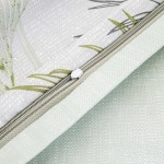 Pościel satyna bawełniana 220x200 w kolorze zielonym z dekoracyjnymi liśćmi. Zamek błyskawiczny wykonany w neutralnym odcieniu. Widoczna tekstura materiału. Produkt ułożony na płasko, z bliskim ujęciem na detal zamka i wzoru.