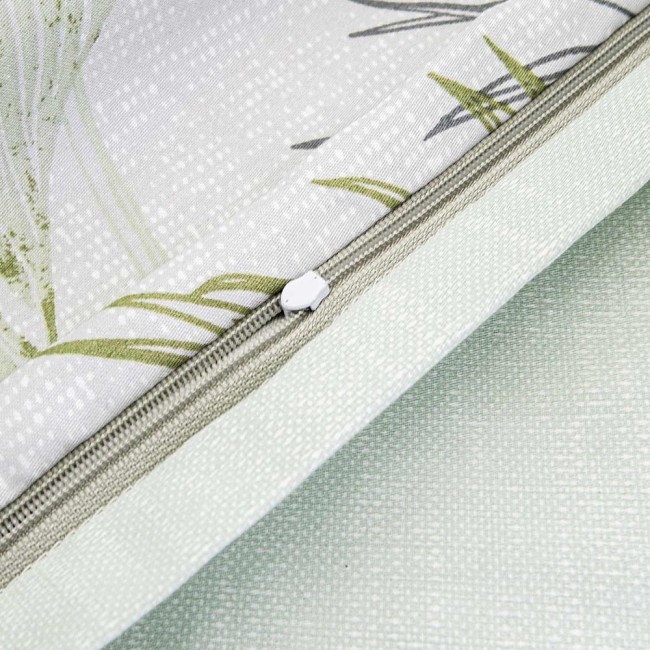 Pościel satyna bawełniana 220x200 w kolorze zielonym z dekoracyjnymi liśćmi. Zamek błyskawiczny wykonany w neutralnym odcieniu. Widoczna tekstura materiału. Produkt ułożony na płasko, z bliskim ujęciem na detal zamka i wzoru.