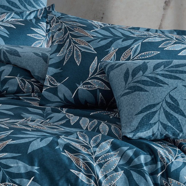 Pościel satyna bawełniana 160x200 Luxury Premium Irene w odcieniach niebieskiego z delikatnymi liśćmi. Ułożona poziomo, z poduszkami w różnych rozmiarach. Tło neutralne, tekstura materiału widoczna. Wzór liści w jasnych kolorach, delikatne detale.