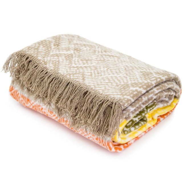 Koc bawełniany 150x200 w kolorach beżowym, żółtym i pomarańczowym, z geometrycznym wzorem i frędzlami. Złożony w prostokąt, widoczny z boku, eksponujący fakturę materiału i wzory. Tło jednolite, neutralne.