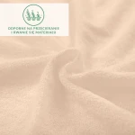 Prześcieradło frotte 160x200 w perłowo-różowym kolorze, leżące w lekkim zrolowaniu, ukazujące teksturę materiału. W tle nieczytelny napis o odporności na przecieranie i rwanie. Widoczne detale tkaniny oraz miękkość powłoki.