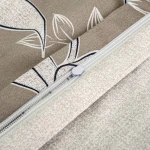 Brązowa pościel satynowa wykonana z bawełny, z dekoracyjnym kwiatowym wzorem. Ujęcie z góry, z widocznym zamkiem i fakturą materiału. Idealna do stworzenia eleganckiej aranżacji sypialni.