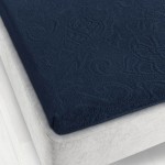Prześcieradło żakardowe bez gumki o wymiarach 175x220 cm w kolorze granatowym, leżące na jasnej, tapicerowanej powierzchni. Widoczny detal tekstury żakardowej, nadający mu elegancki wygląd.