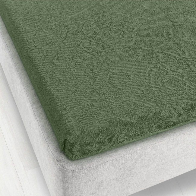 Prześcieradło żakardowe bez gumki w kolorze zielonym, z fakturą o wyraźnym splocie, leży na materacu o szarej obudowie. Widoczne jest jego przyleganie do krawędzi materaca w zestawieniu z jasnym, jednolitym tłem podłogi. Wymiary: 175x220 cm.