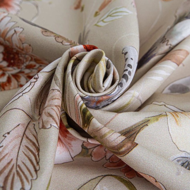 Pościel bawełniana 200x220 Cottonlove Exclusive Sidelya, beżowa, z kolorowymi kwiatami, leżąca w formie złożonego rulonu. Wzory kwiatowe i liściaste, delikatna faktura materiału. Tło proste, bez zakłóceń, co podkreśla szczegóły wzoru.