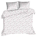 Pościel z kory 140x200 w białym kolorze z delikatnym różowym wzorem w róże. Produkt leżący na płasko, w pełni rozłożony, z widocznymi dwoma poszewkami na poduszki. Tło jednolite, co podkreśla detale tkaniny i wzoru.